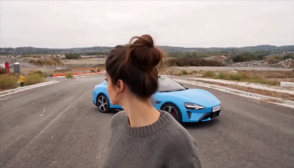 Man’s Not Hot example with a grey-sweater lead and blue sports car